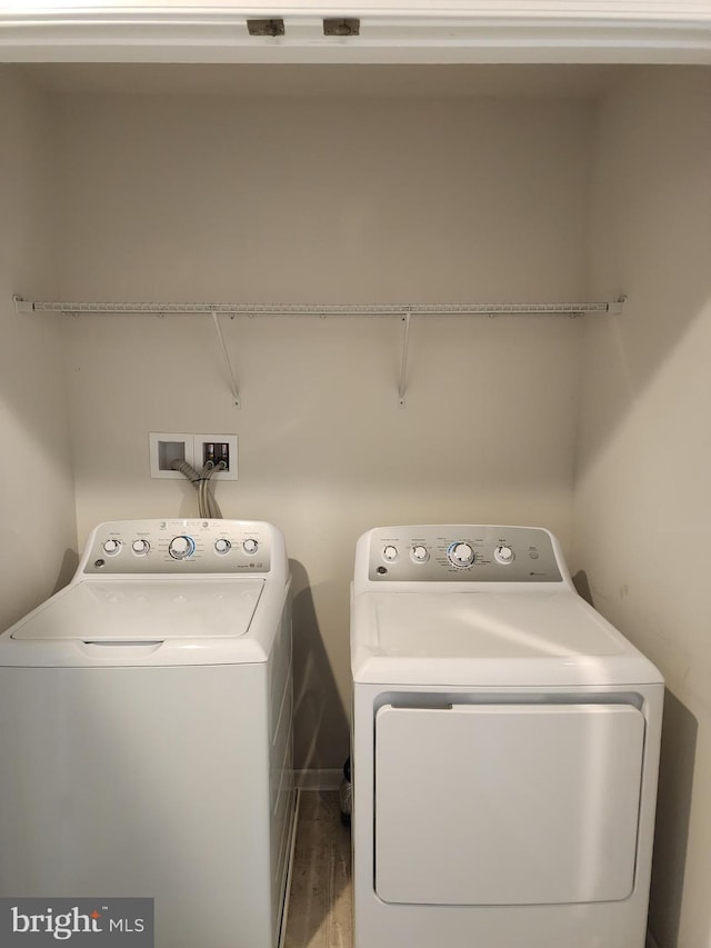 laundry room featuring washing machine and dryer, wood finished floors, and laundry area