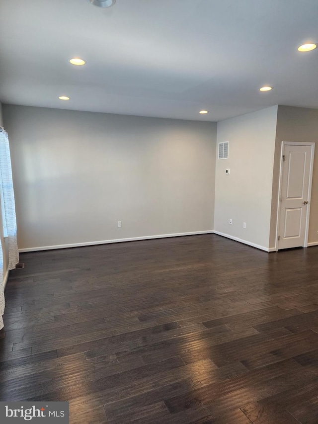 unfurnished room featuring dark wood-type flooring, visible vents, and recessed lighting