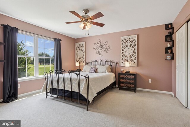 carpeted bedroom with baseboards, ceiling fan, and a closet