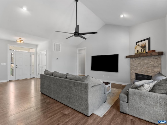 3185 Polecat Creek Ln, Scottsville, VA 24590 - living room with visible vents, lofted ceiling, wood finished floors, ceiling fan, and a stone fireplace