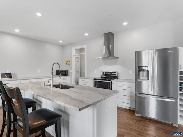 3185 Polecat Creek Ln, Scottsville, VA 24590 - kitchen featuring a sink, wall chimney exhaust hood, a kitchen bar, appliances with stainless steel finishes, and white cabinetry