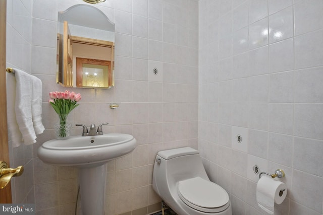 half bathroom with tile walls and toilet