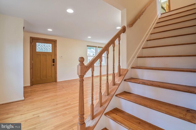 entrance foyer with recessed lighting, light wood-type flooring, stairway, and baseboards