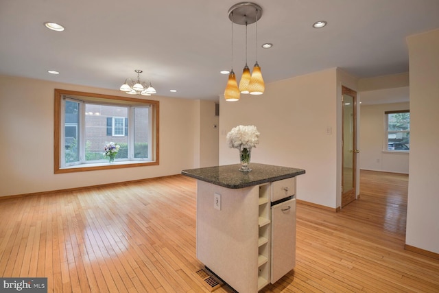 kitchen with baseboards, a chandelier, light wood-style floors, a center island, and hanging light fixtures