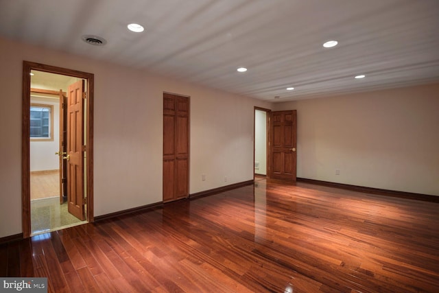 unfurnished room with dark wood-style flooring, baseboards, and recessed lighting