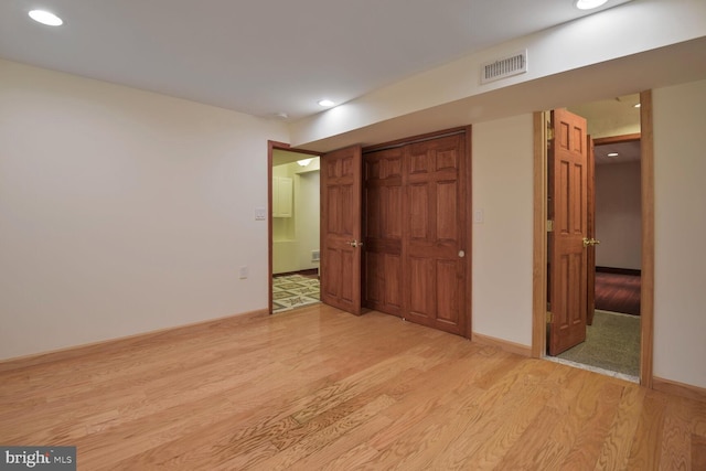 unfurnished bedroom featuring light wood finished floors, recessed lighting, and a closet