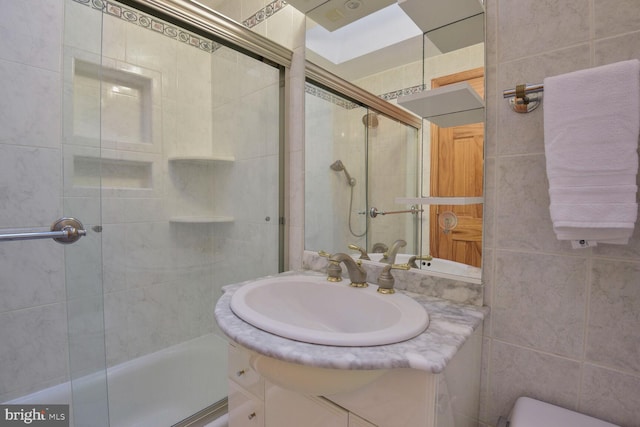 bathroom featuring tile walls, vanity, and toilet