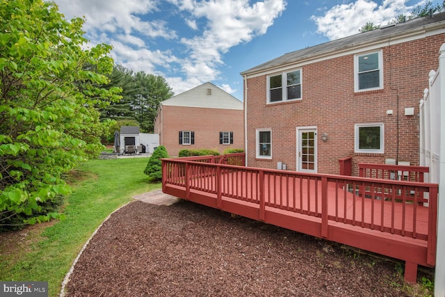 rear view of house featuring a wooden deck, brick siding, and a yard