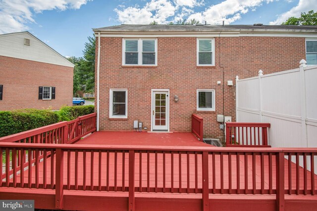 back of property with a deck and brick siding