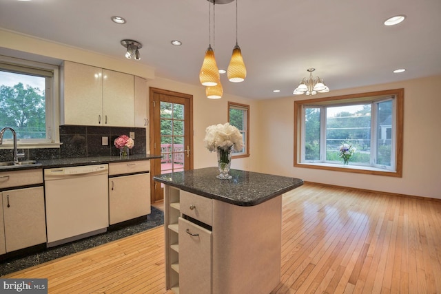 kitchen with white dishwasher, a sink, healthy amount of natural light, backsplash, and recessed lighting