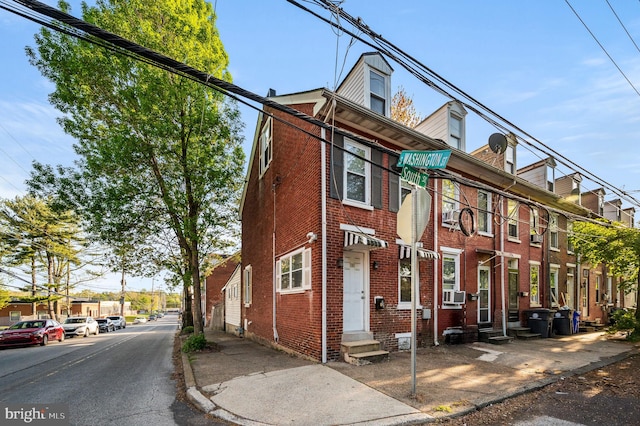 townhome / multi-family property featuring brick siding and entry steps