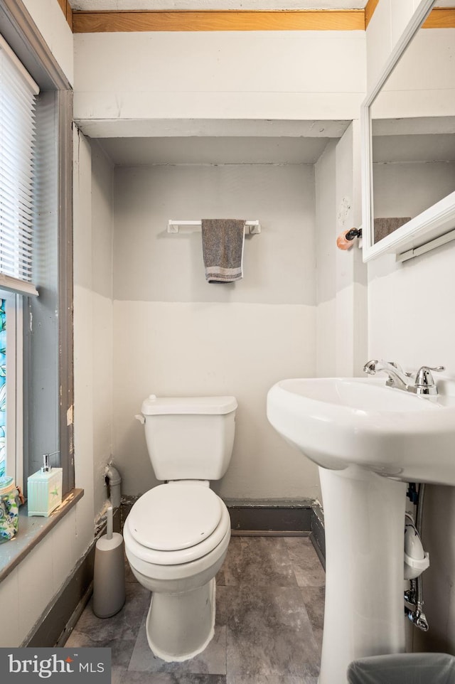 bathroom featuring baseboards and toilet