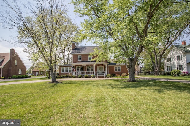 23075 Hollywood Rd, Leonardtown, MD 20650 - view of front of property featuring a chimney, a front lawn, brick siding, and covered porch