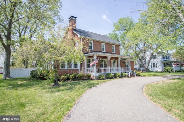 23075 Hollywood Rd, Leonardtown, MD 20650 - view of front of property featuring brick siding, a porch, a front lawn, and fence