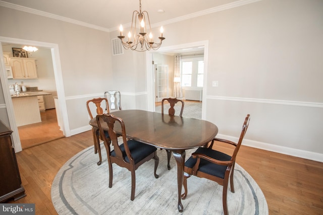 23075 Hollywood Rd, Leonardtown, MD 20650 - dining area featuring radiator heating unit, light wood finished floors, an inviting chandelier, visible vents, and baseboards