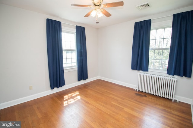 23075 Hollywood Rd, Leonardtown, MD 20650 - spare room featuring wood finished floors, ceiling fan, radiator, baseboards, and visible vents