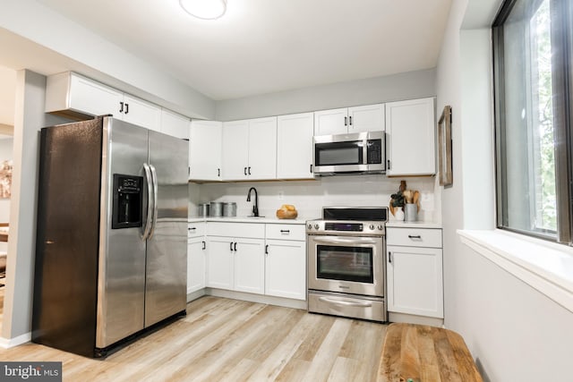 7374 Hickory Log Cir, Columbia, MD 21045 - kitchen featuring stainless steel appliances, light wood-type flooring, light countertops, and white cabinets