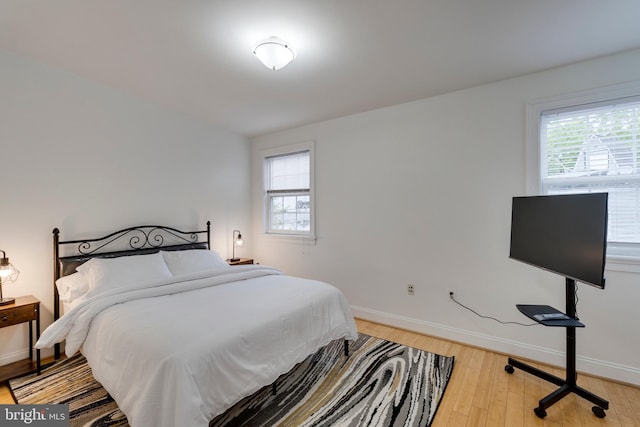 bedroom with baseboards and light wood-type flooring