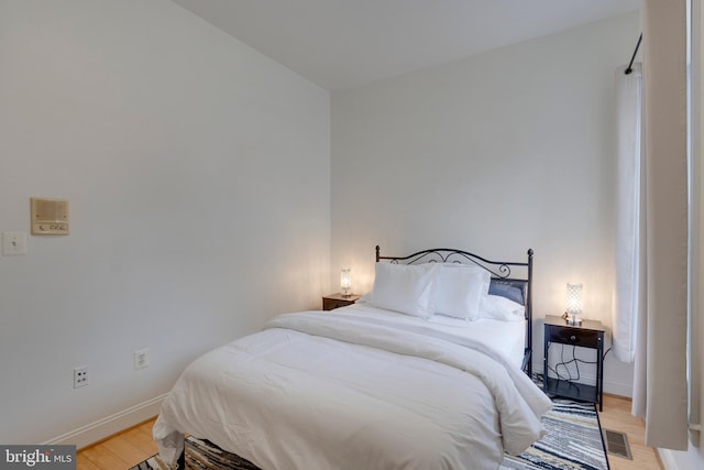 bedroom featuring baseboards, visible vents, and light wood-type flooring