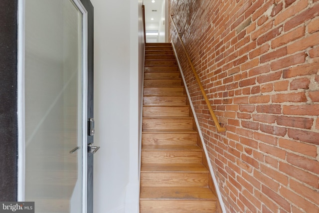 stairs featuring brick wall