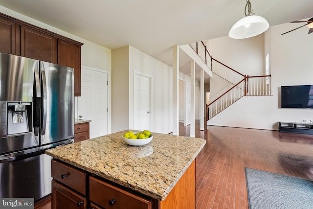 17365 Tedler Cir, Round Hill, VA 20141 - kitchen with stainless steel fridge with ice dispenser, light stone counters, dark wood finished floors, and a center island