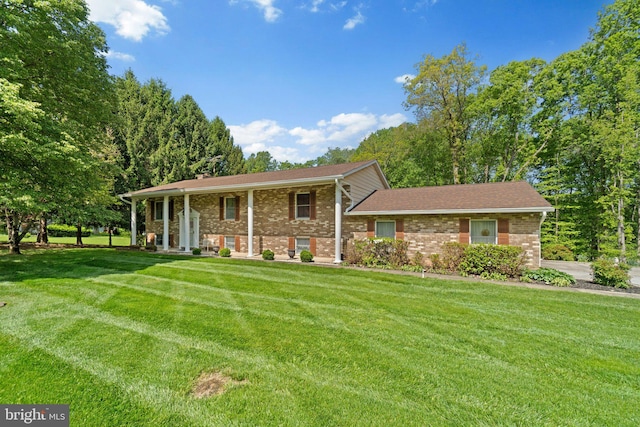 view of front of house featuring a front lawn, brick siding, and covered porch