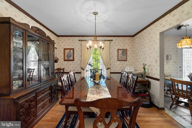 dining area with light wood-style flooring, a chandelier, wallpapered walls, and ornamental molding