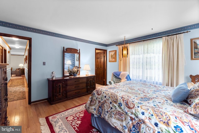 bedroom with light wood-type flooring and baseboards