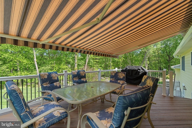 deck with outdoor dining space and grilling area