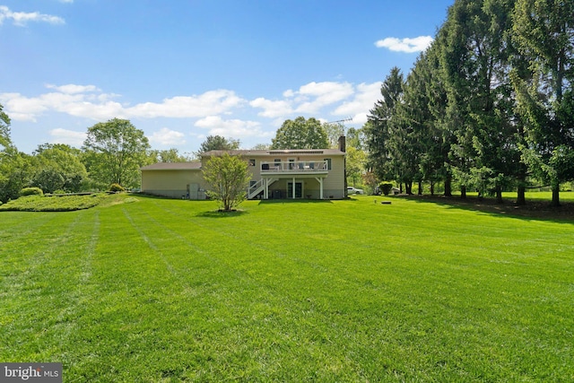 view of grassy yard with a wooden deck and stairway