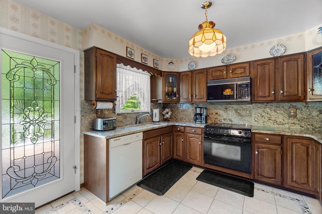 kitchen featuring dishwasher, oven, a sink, wallpapered walls, and tasteful backsplash