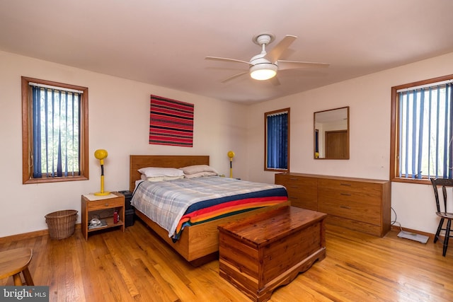 bedroom featuring light wood-type flooring, a ceiling fan, and baseboards