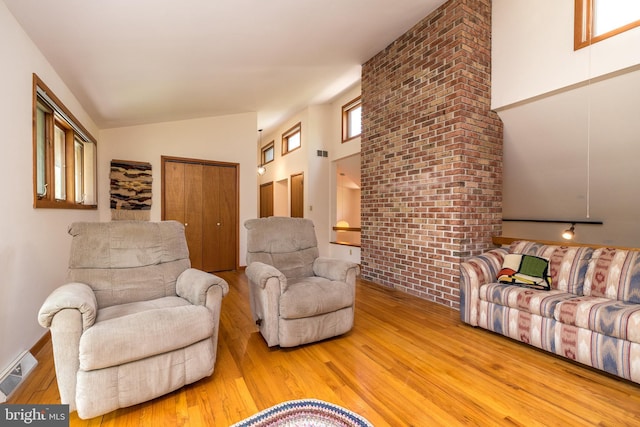 living room featuring visible vents, high vaulted ceiling, and wood finished floors
