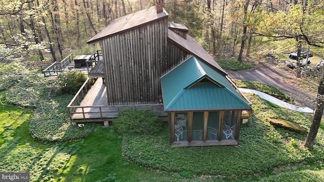 view of outbuilding featuring a sunroom and a wooded view