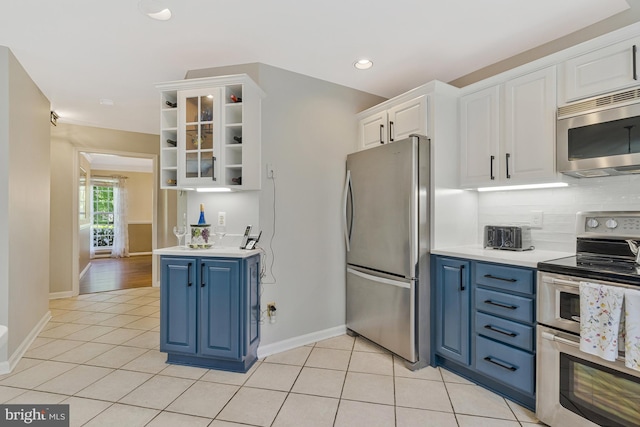 15427 Martins Hundred Dr, Centreville, VA 20120 - kitchen with baseboards, white cabinetry, appliances with stainless steel finishes, blue cabinetry, and light tile patterned floors