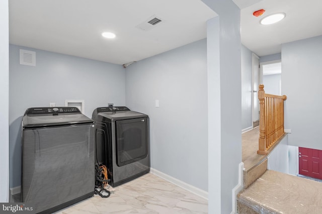 clothes washing area with separate washer and dryer, baseboards, marble finish floor, and visible vents