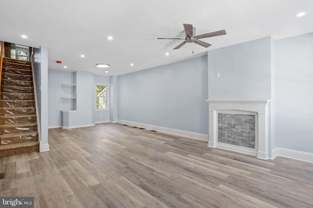 unfurnished living room with stairway, wood finished floors, ceiling fan, baseboards, and recessed lighting