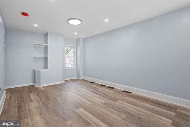 interior space featuring baseboards, wood finished floors, visible vents, and recessed lighting