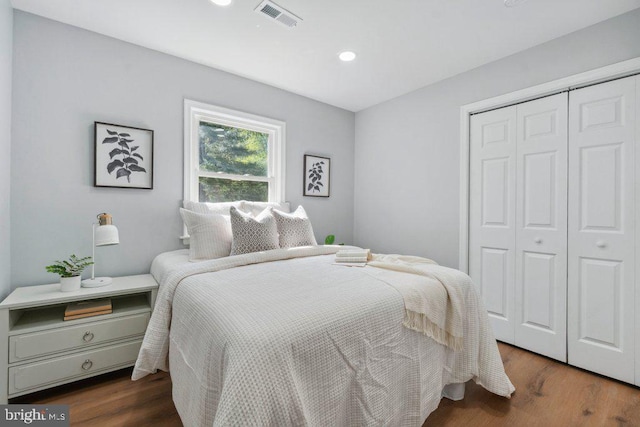 bedroom featuring recessed lighting, visible vents, wood finished floors, and a closet
