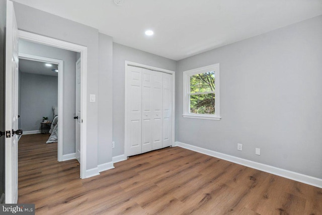 unfurnished bedroom with baseboards, recessed lighting, and wood finished floors