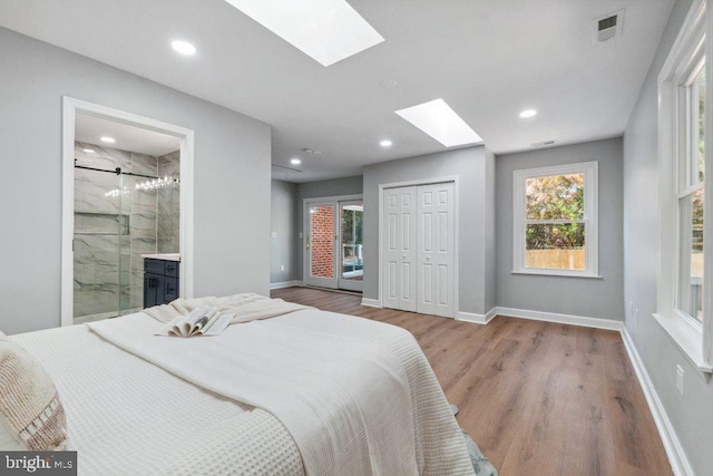 bedroom featuring visible vents, wood finished floors, baseboards, recessed lighting, and a skylight
