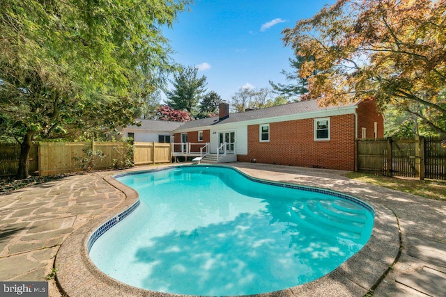 view of swimming pool with a patio, a fenced in pool, a fenced backyard, and a diving board
