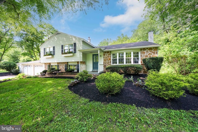 413 Bucktoe Rd, Avondale, PA 19311 - tri-level home featuring stone siding, a chimney, an attached garage, and a front lawn
