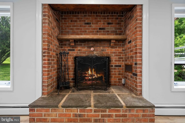 413 Bucktoe Rd, Avondale, PA 19311 - detailed view of a baseboard heating unit, a brick fireplace, and wood finished floors