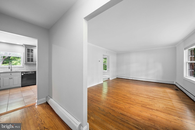 413 Bucktoe Rd, Avondale, PA 19311 - spare room with a baseboard radiator, light wood-type flooring, a sink, baseboards, and crown molding