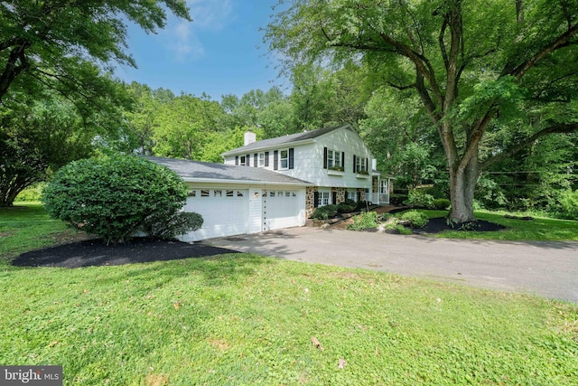 413 Bucktoe Rd, Avondale, PA 19311 - view of front of property with asphalt driveway, a front lawn, an attached garage, and a chimney