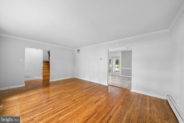 413 Bucktoe Rd, Avondale, PA 19311 - spare room featuring a baseboard radiator, light wood-style floors, stairway, ornamental molding, and baseboards
