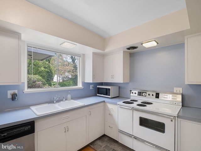 kitchen with a sink, light countertops, white cabinets, and white appliances