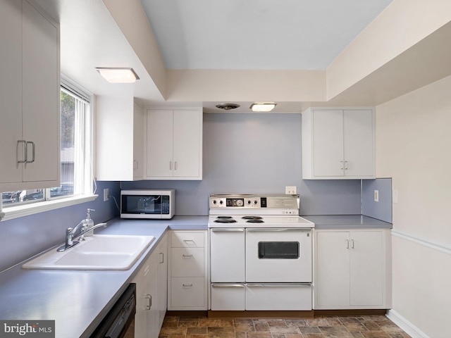 kitchen with black dishwasher, white cabinetry, stainless steel microwave, a sink, and double oven range
