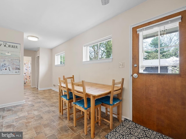 dining room featuring baseboards, visible vents, and stone finish floor
